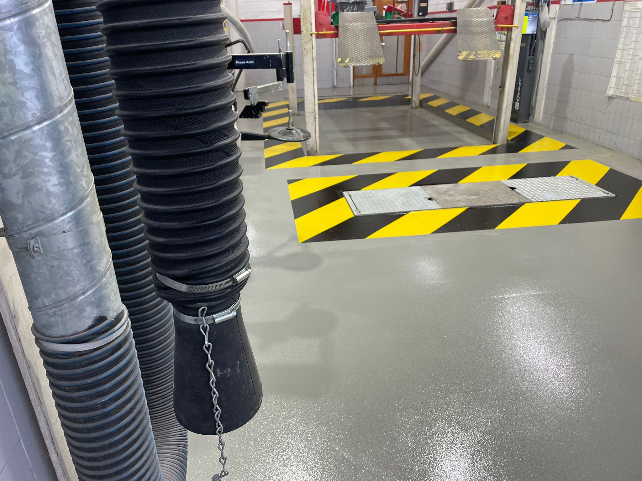 vehicle workshop floor grey resin finish hatched bay resin line marking black and yellow